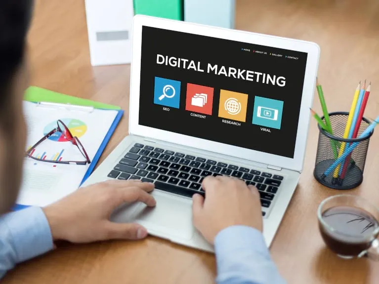 Close-up of a laptop showing 4, large icons, related to digital marketing.